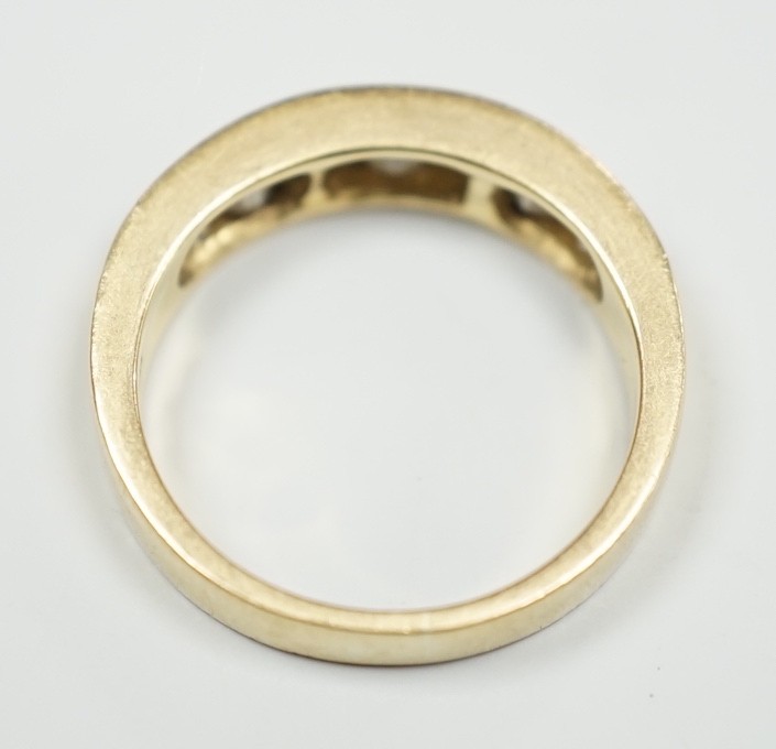 An 18k yellow metal, four stone round cut and three stone rectangular cut channel set diamond half hoop ring, size L, gross weight 4.9 grams.